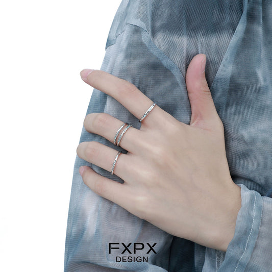 Stylish FXPX ocean breeze ring worn on a hand with multiple elegant rings