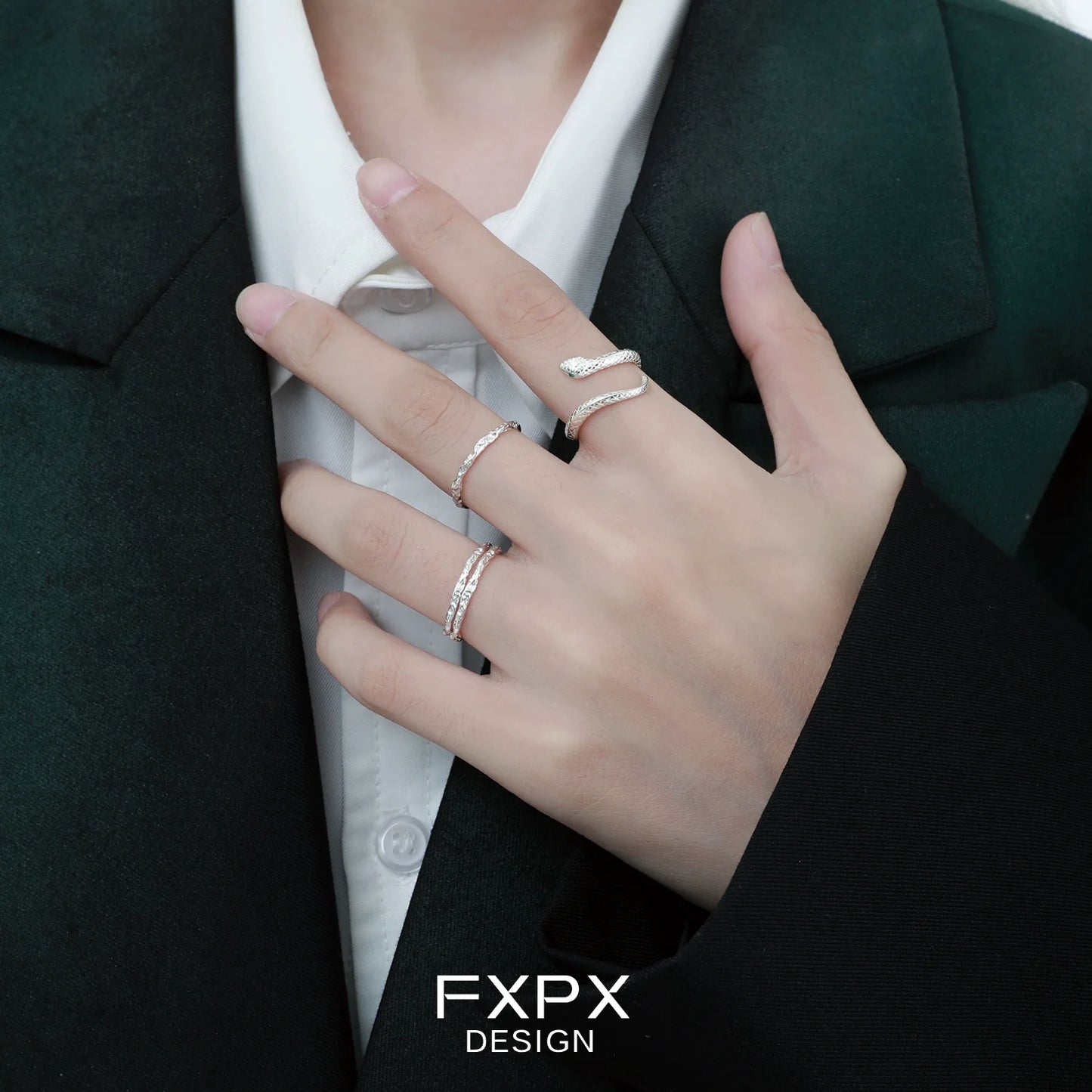 Stylish Ouroboros silver ring worn on a finger with other delicate rings for a modern look