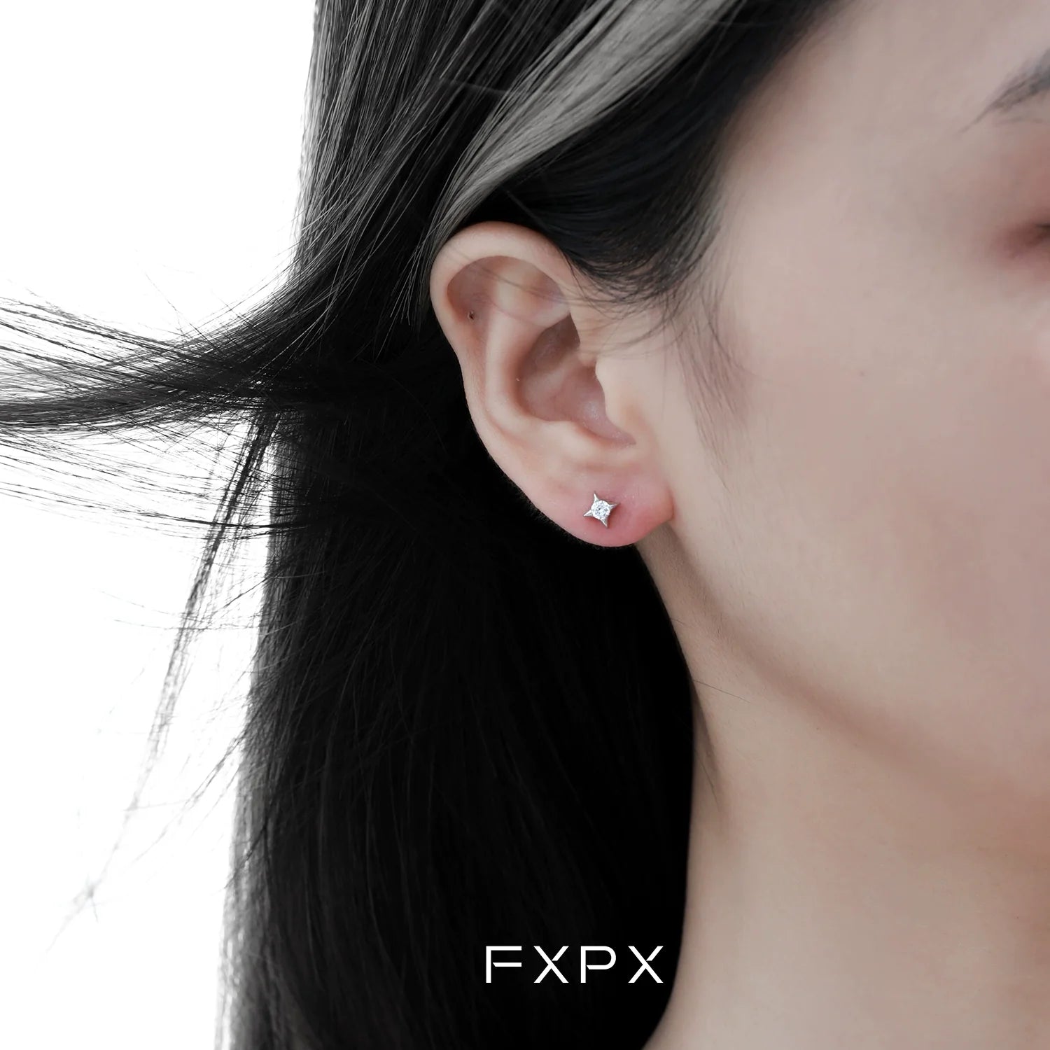 Radiant star silver stud earrings showcased on a model's ear for a sparkling look