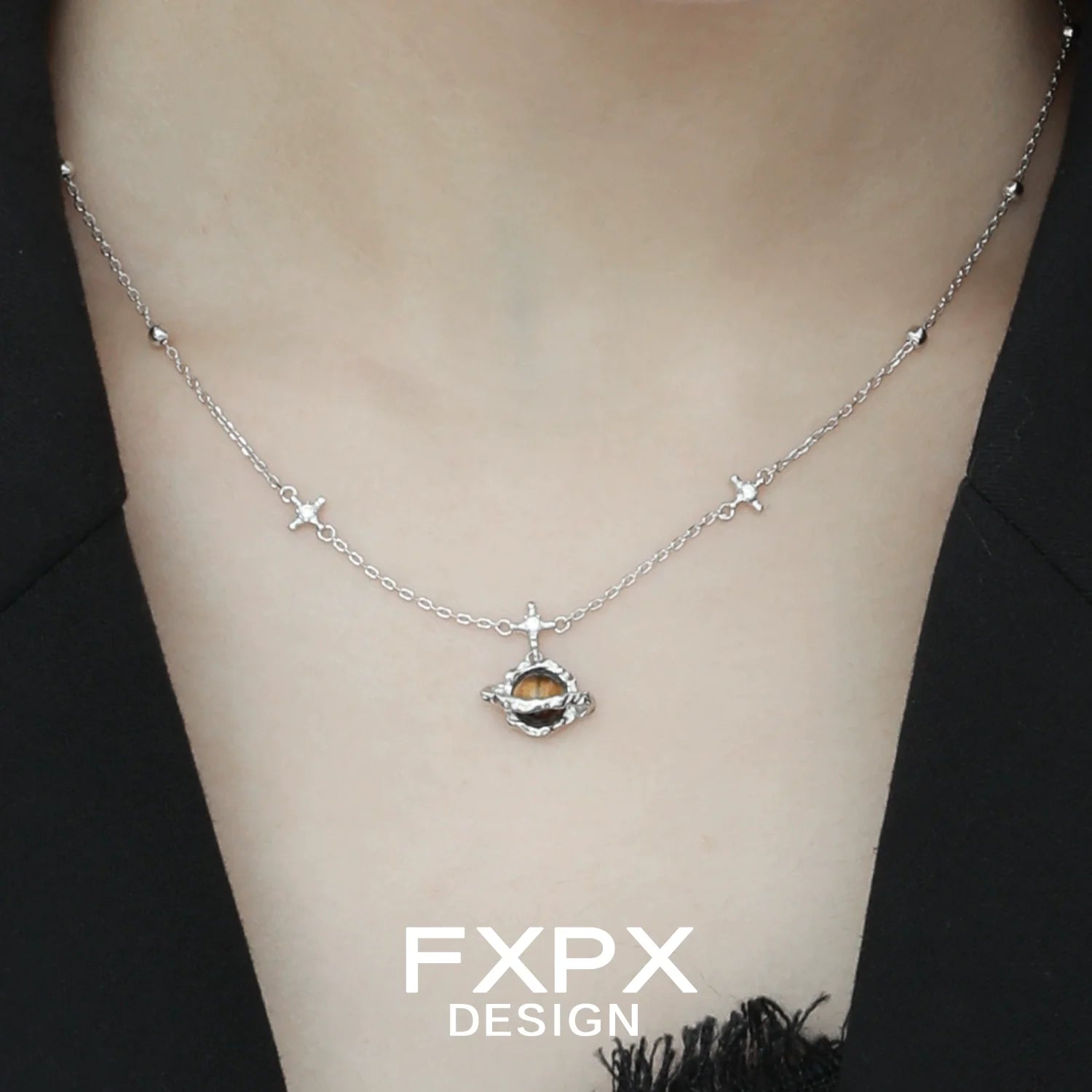 FXPX Saturn tiger's eye necklace on a model, featuring a silver chain and unique design