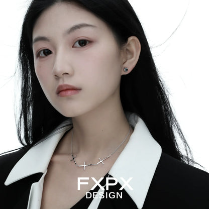 Elegant FXPX silver cross necklace worn by a model against a white background