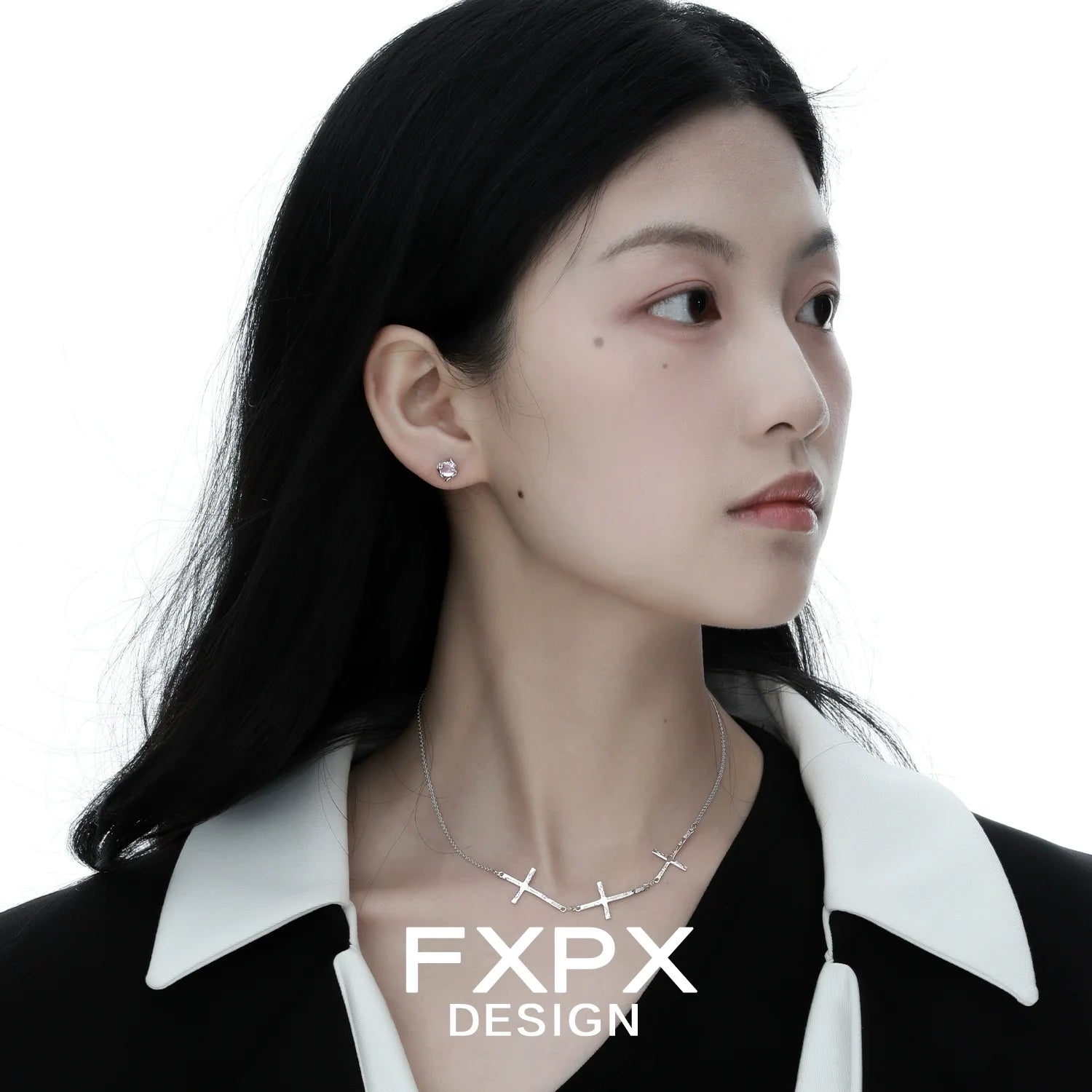 Elegant FXPX silver cross necklace showcased on a model with sleek hair and minimalistic earrings