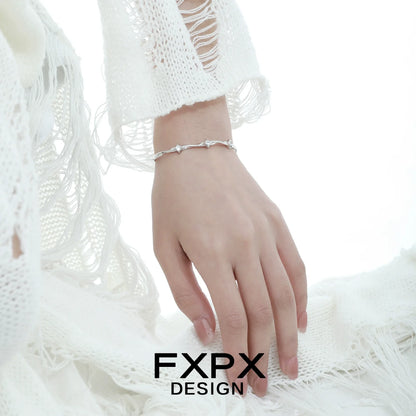 Elegant FXPX silver star bracelet displayed on a model's wrist, showcasing its delicate design