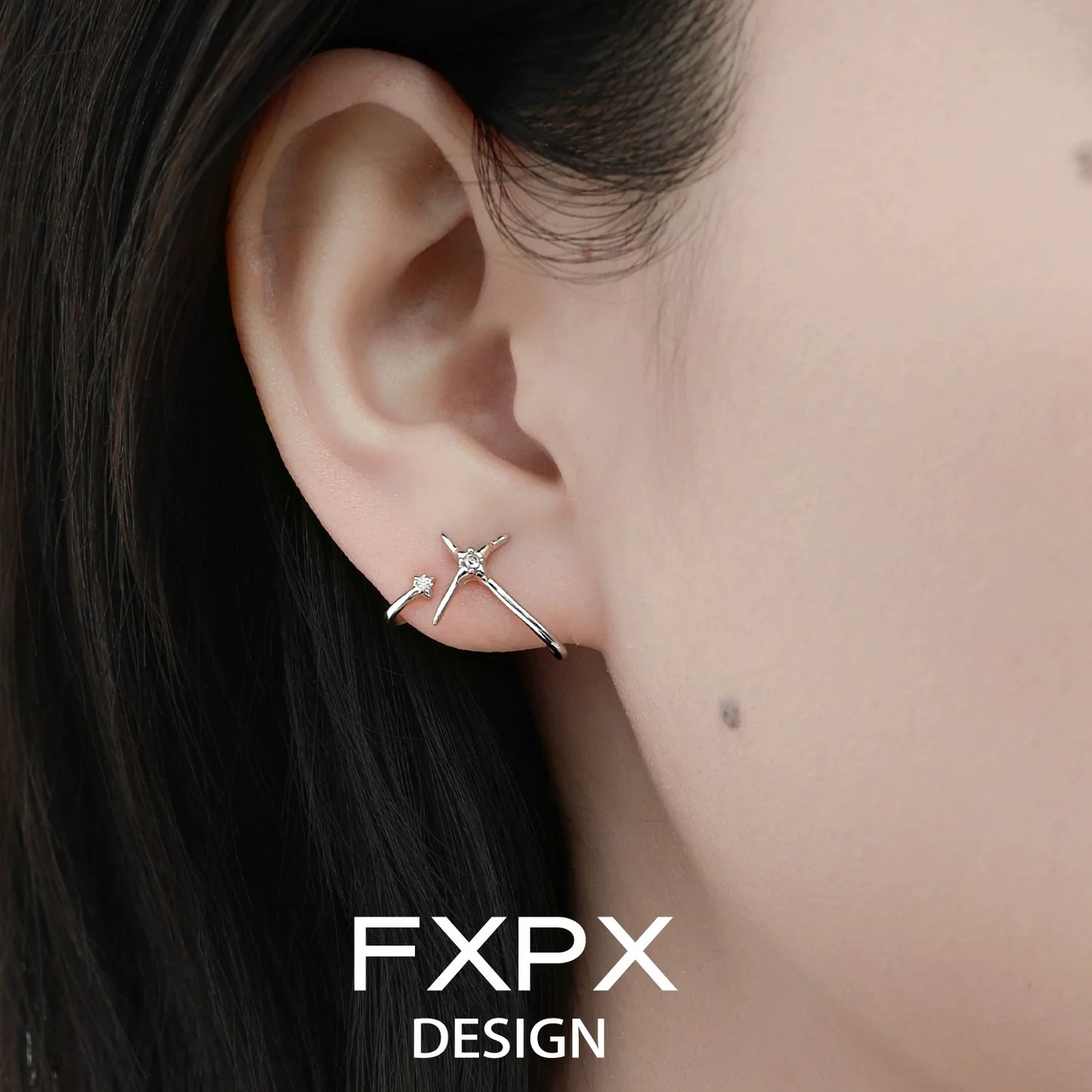 Stylish FXPX silver star track earrings displayed on a model's ear