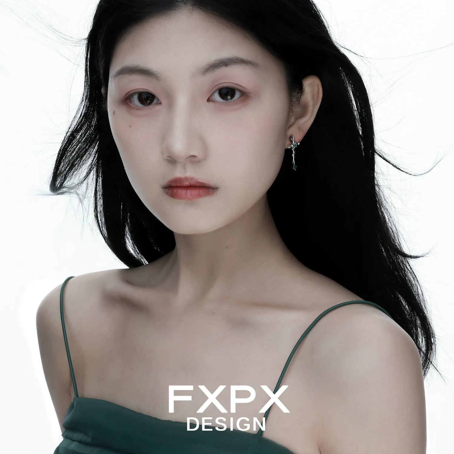 Model wearing FXPX snake cross earrings with a sleek hairstyle and minimal makeup