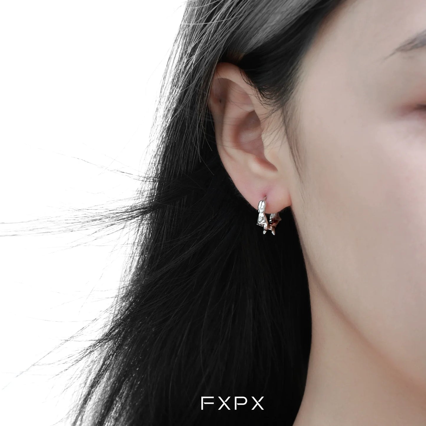 Thorn silver hoop earrings worn by a model with long dark hair for a stylish look