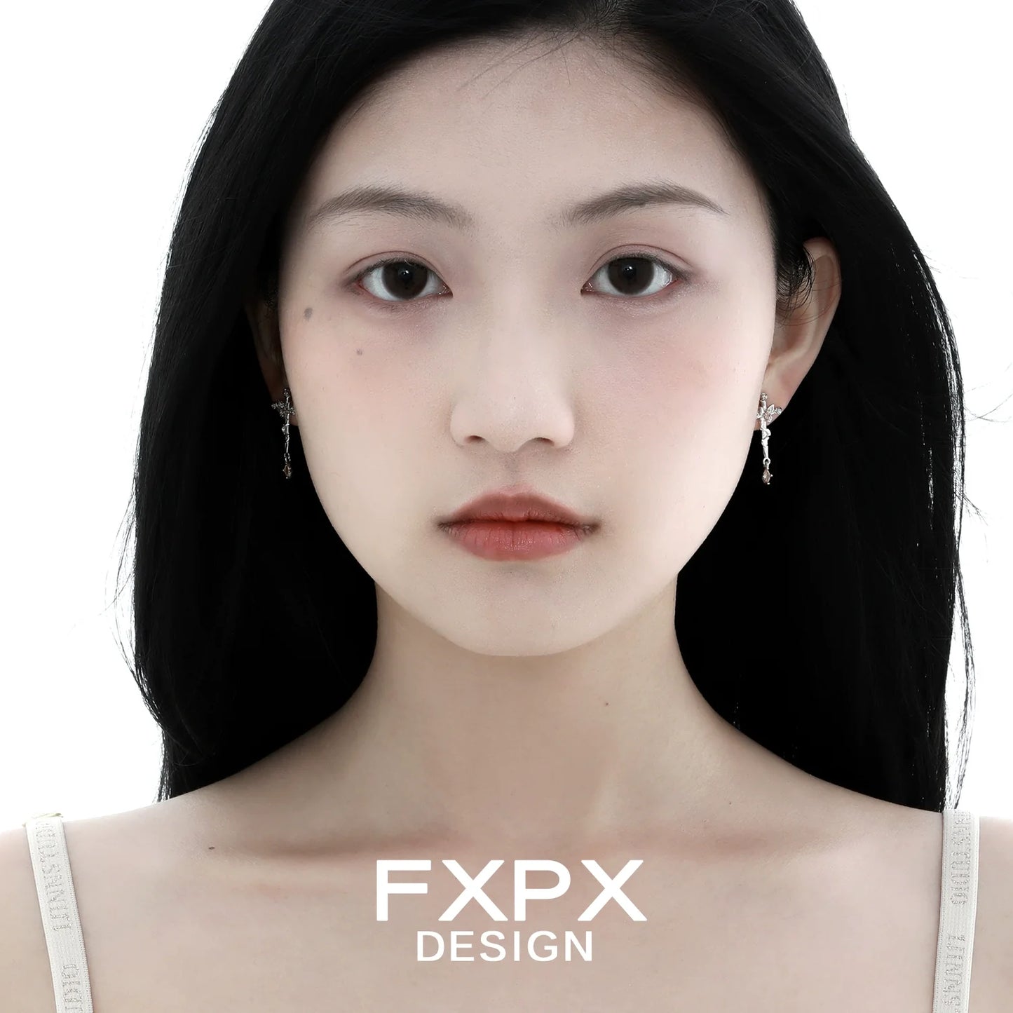 Model wearing FXPX thorned butterfly cross earrings in a stylish design