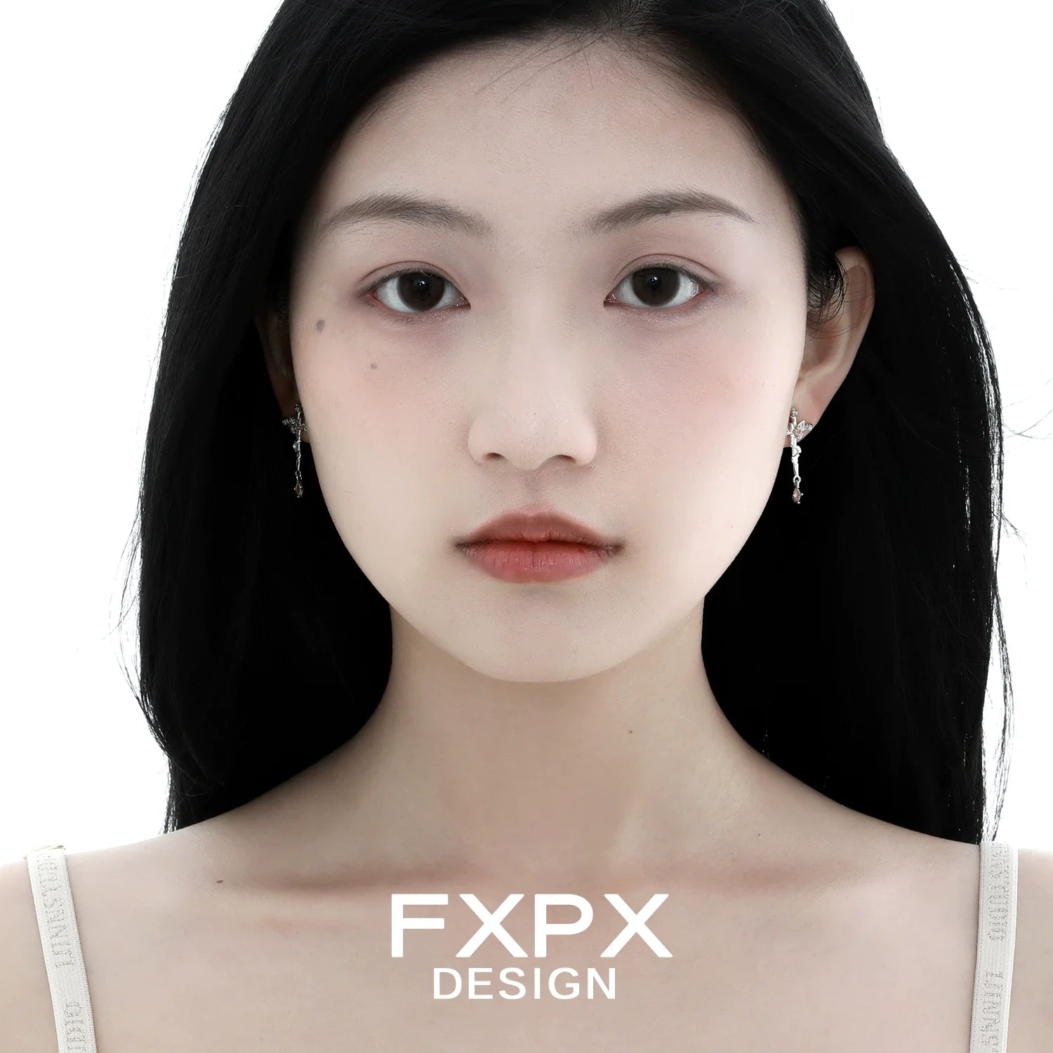 Model wearing FXPX thorned butterfly cross earrings in a stylish design