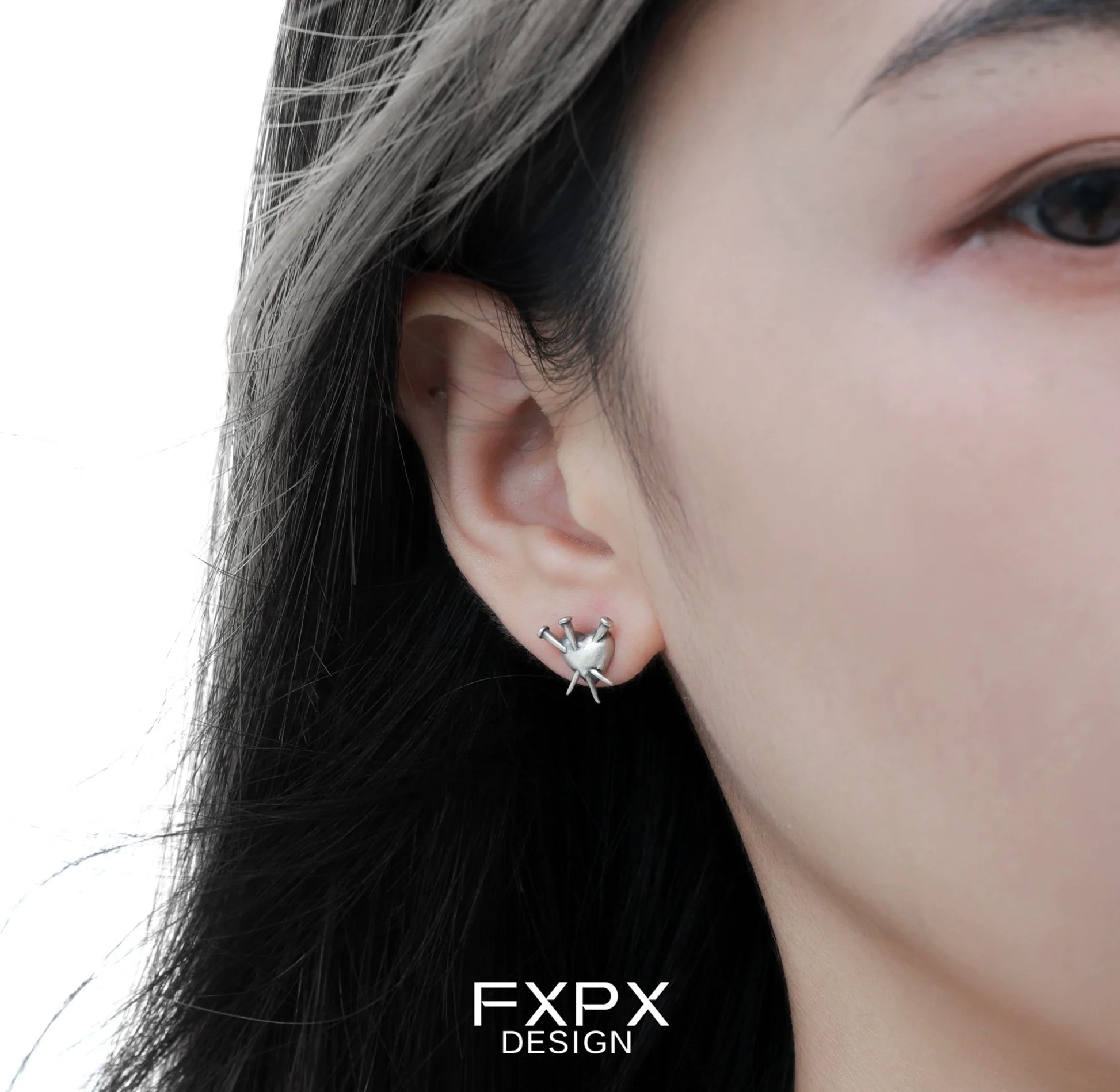 FXPX vintage punk silver earrings displayed on model's ear for a stylish edgy look