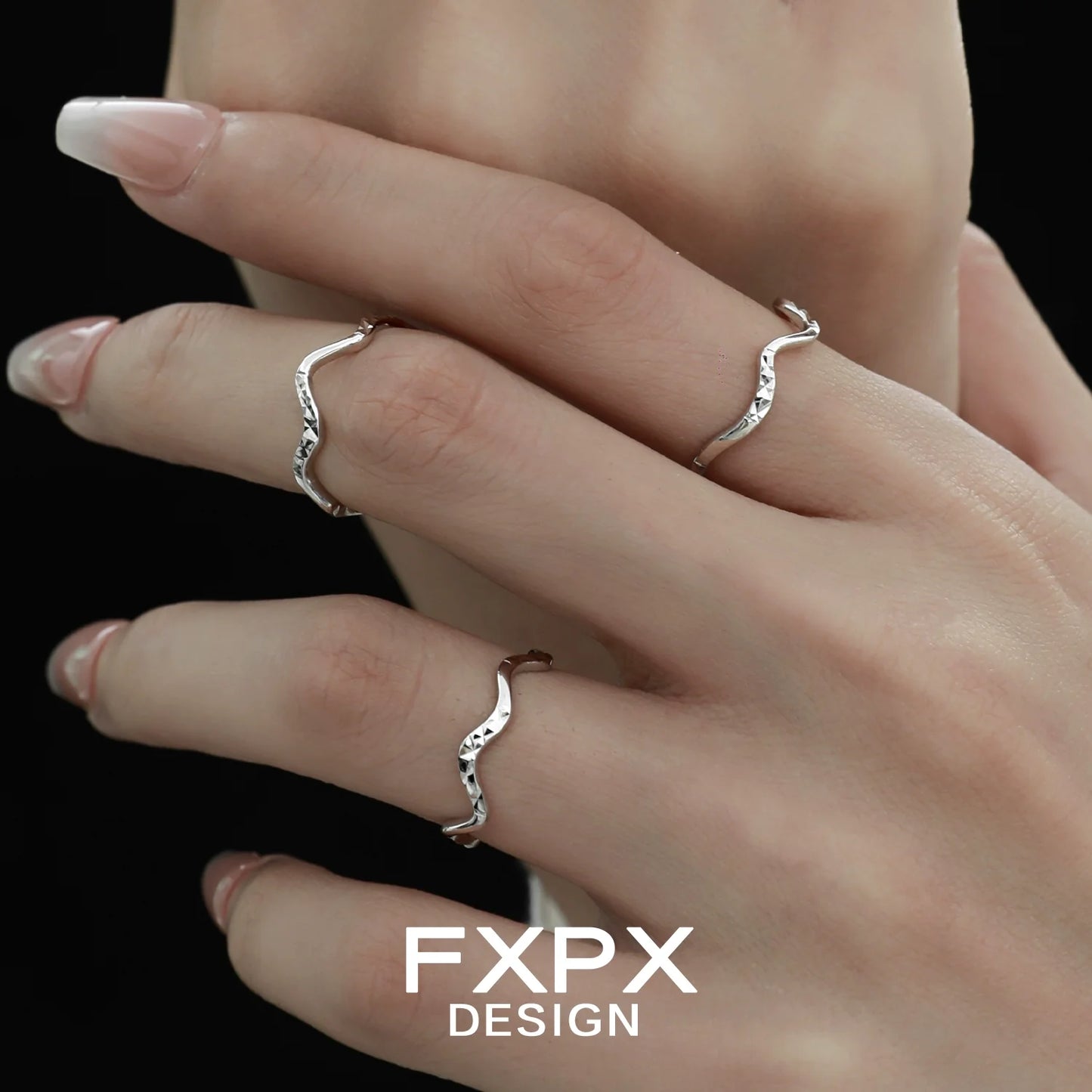 Stylish wavy silver ring showcased on elegant fingers with long nails