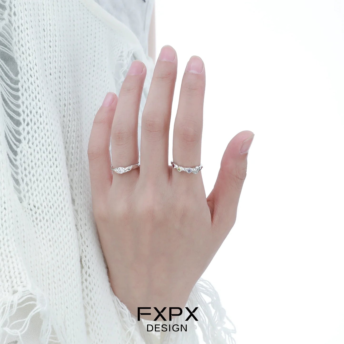Elegant FXPX white zircon ring displayed on a hand with a soft knit background