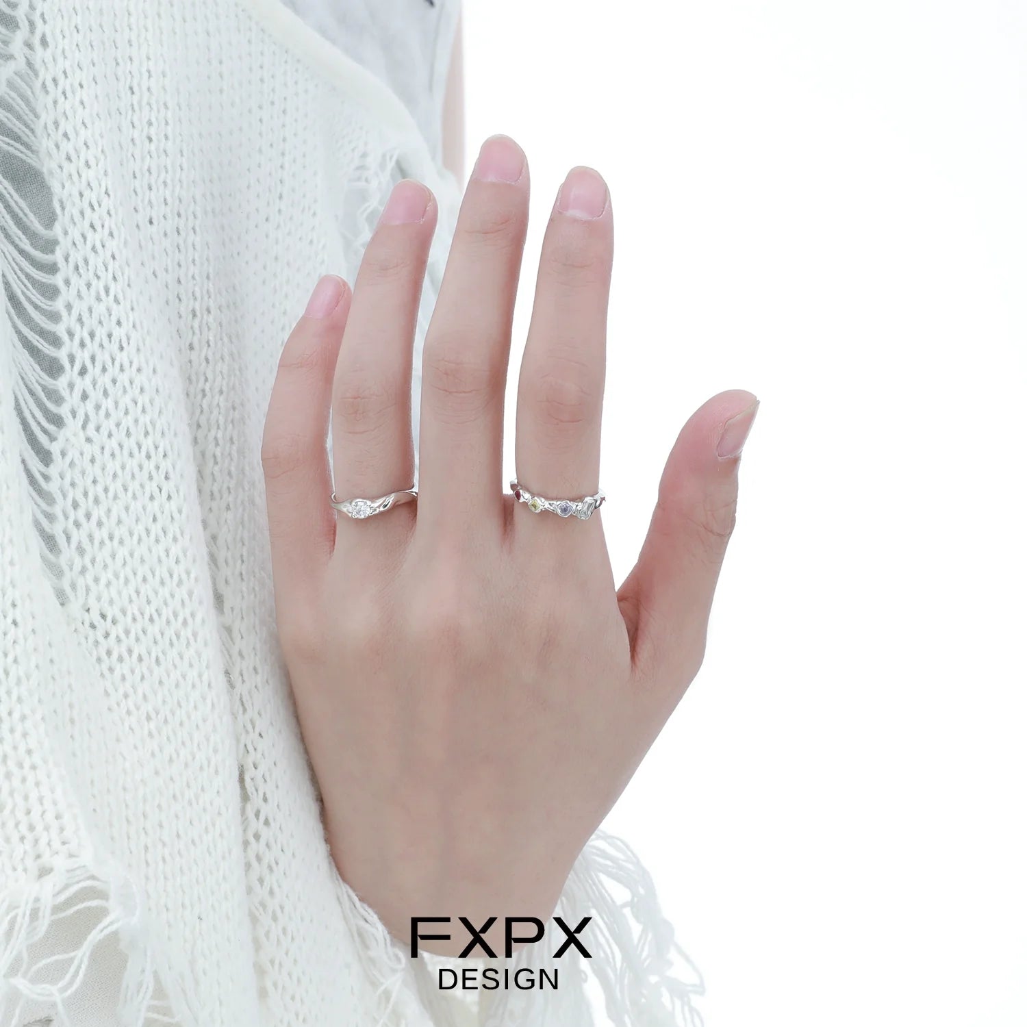 Elegant FXPX white zircon ring displayed on a hand with a soft knit background