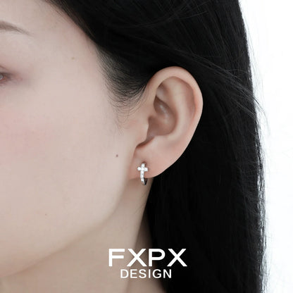 Silver FXPX Y2K cross earrings showcased on a model's ear for a trendy accessory look