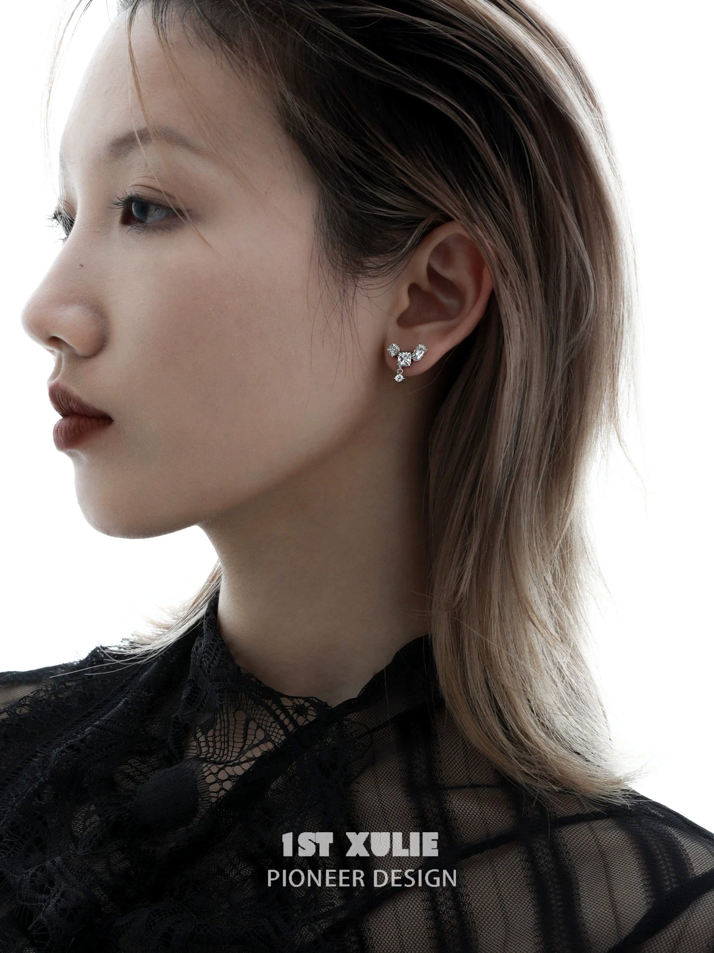 Geometric silver earrings with a unique design showcased on a model's ear for modern fashion enthusiasts