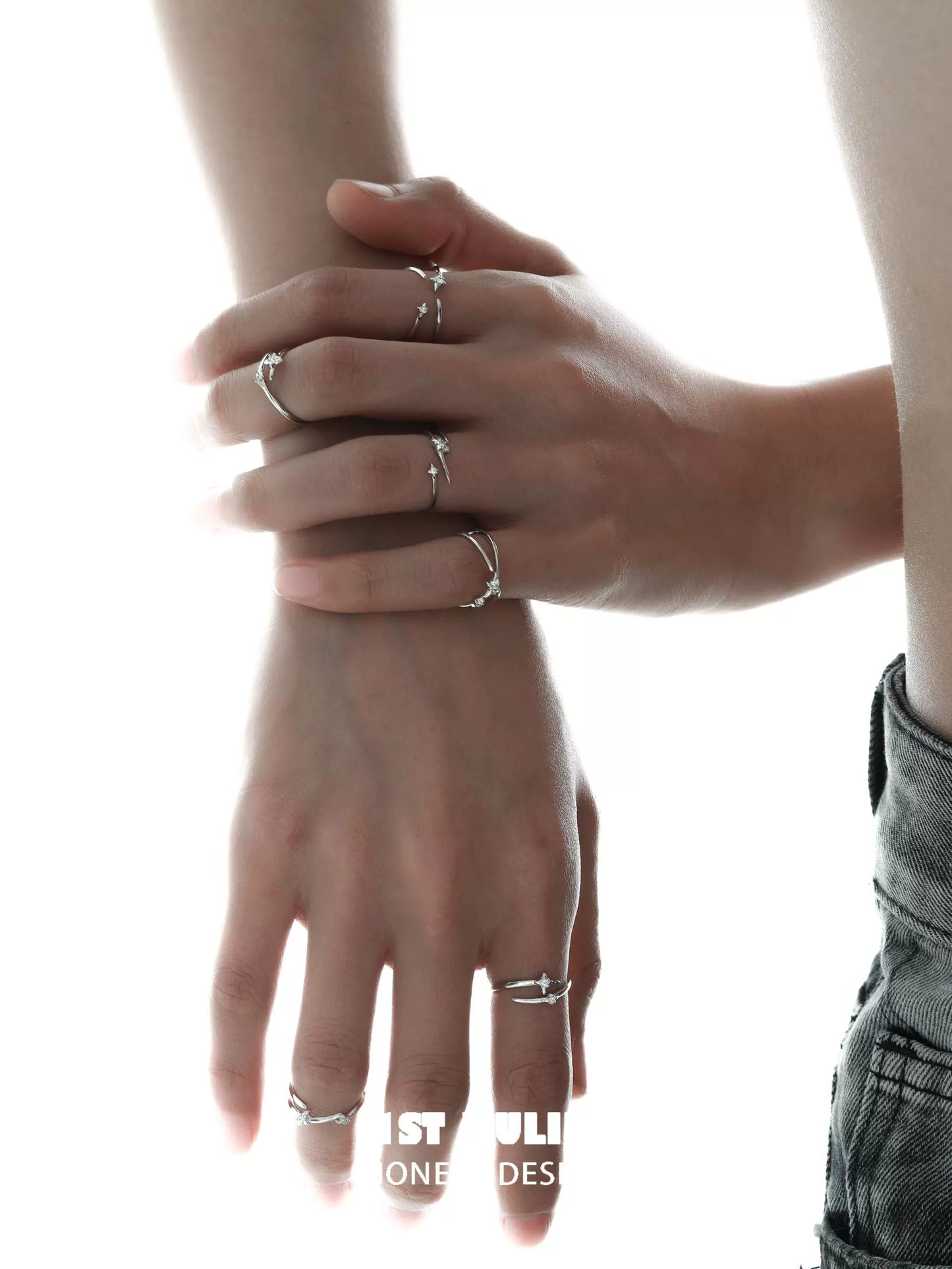 Stylish geometric silver ring displayed on hands with modern design and intricate details