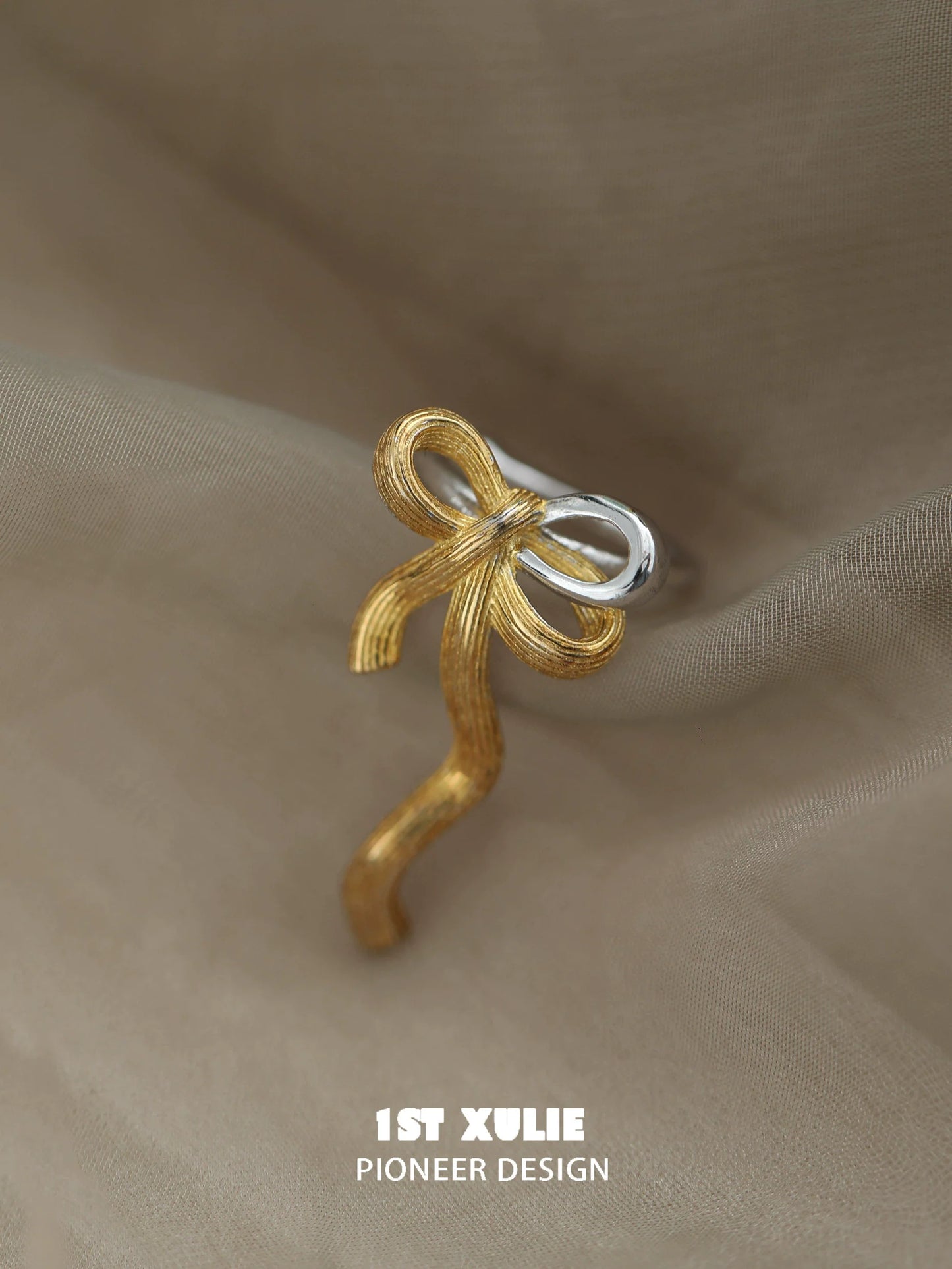 Gold bow ear cuff designed by 1STXULIE with intricate detailing for a stylish accessory