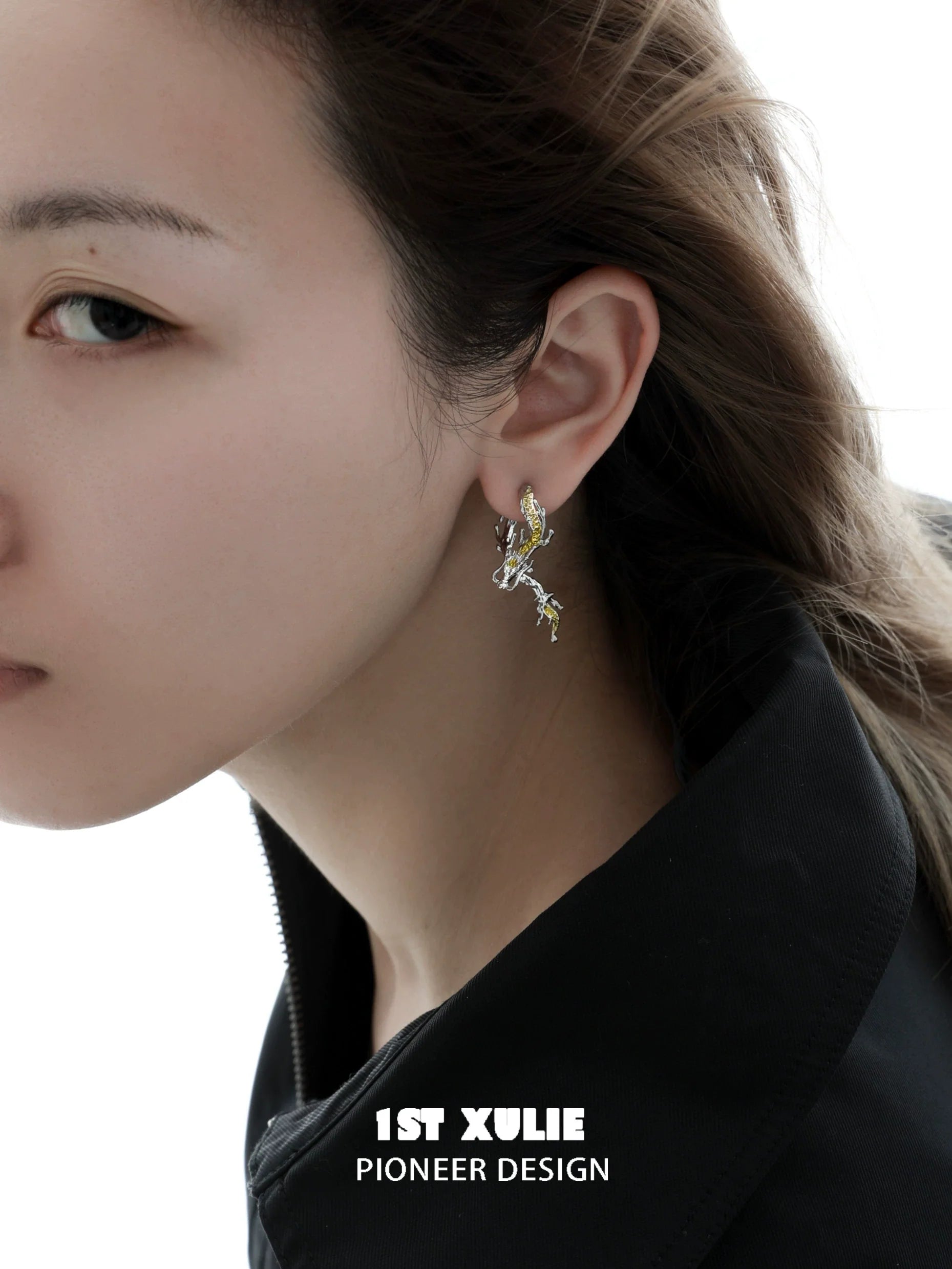 Gold dragon stud earrings in a stylish design worn by a model with flowing hair