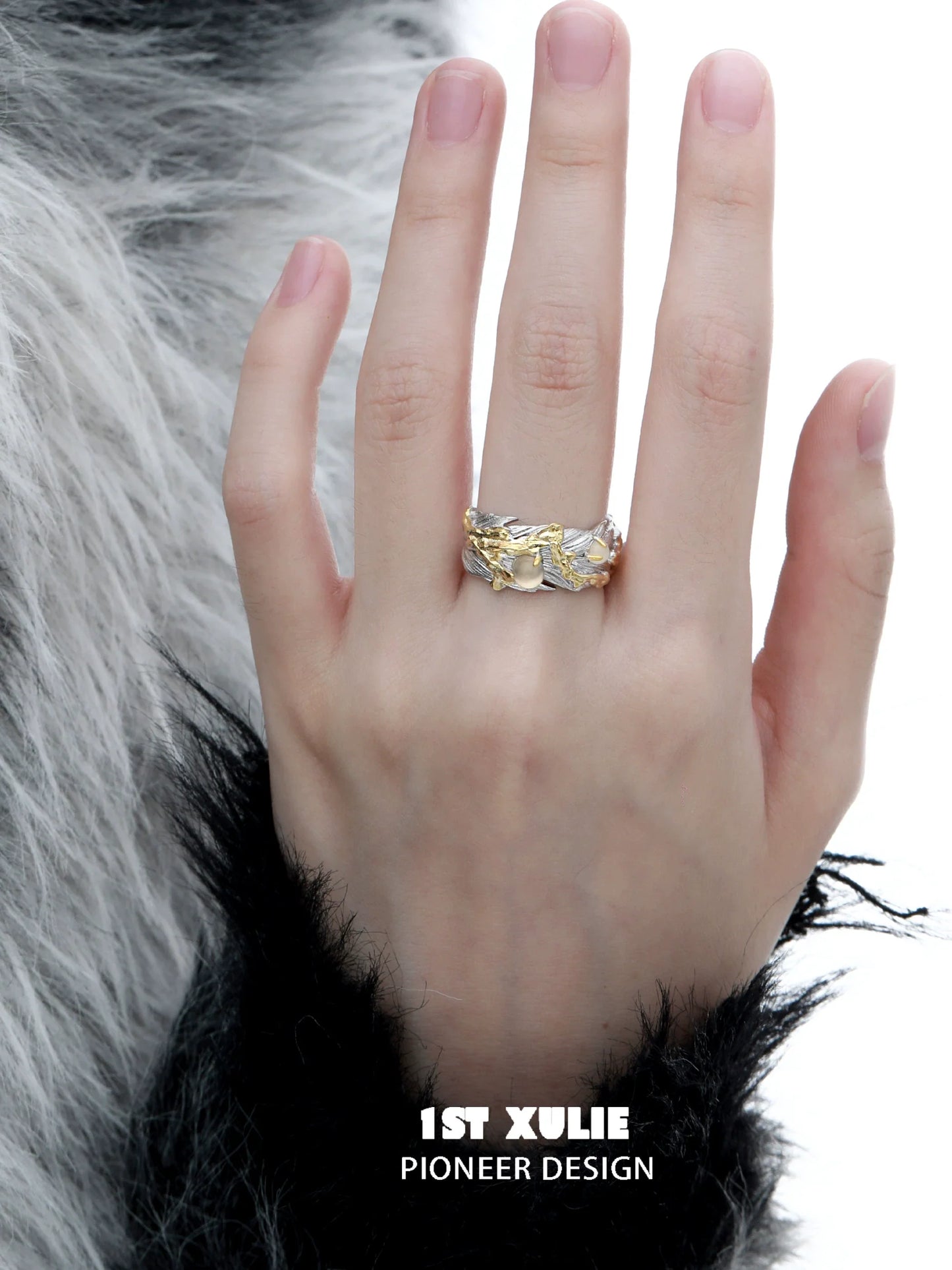 Gold feather ring on a hand with a textured background for elegant style