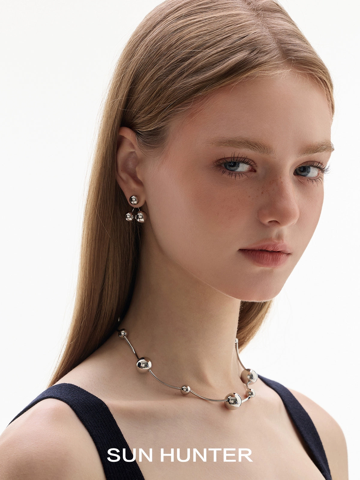 Woman wearing SUN HUNTER jewelry planet silver necklace for women from Gothhalo Jewelry with elegant earrings