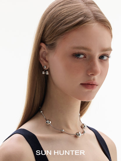 Woman wearing SUN HUNTER jewelry planet silver necklace for women from Gothhalo Jewelry with elegant earrings