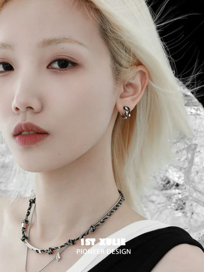 Gothic black rattlesnake earrings showcased on a model with a minimalist style