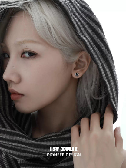 Elegant model showcasing gothic butterfly earrings in a chic striped hoodie for a modern look