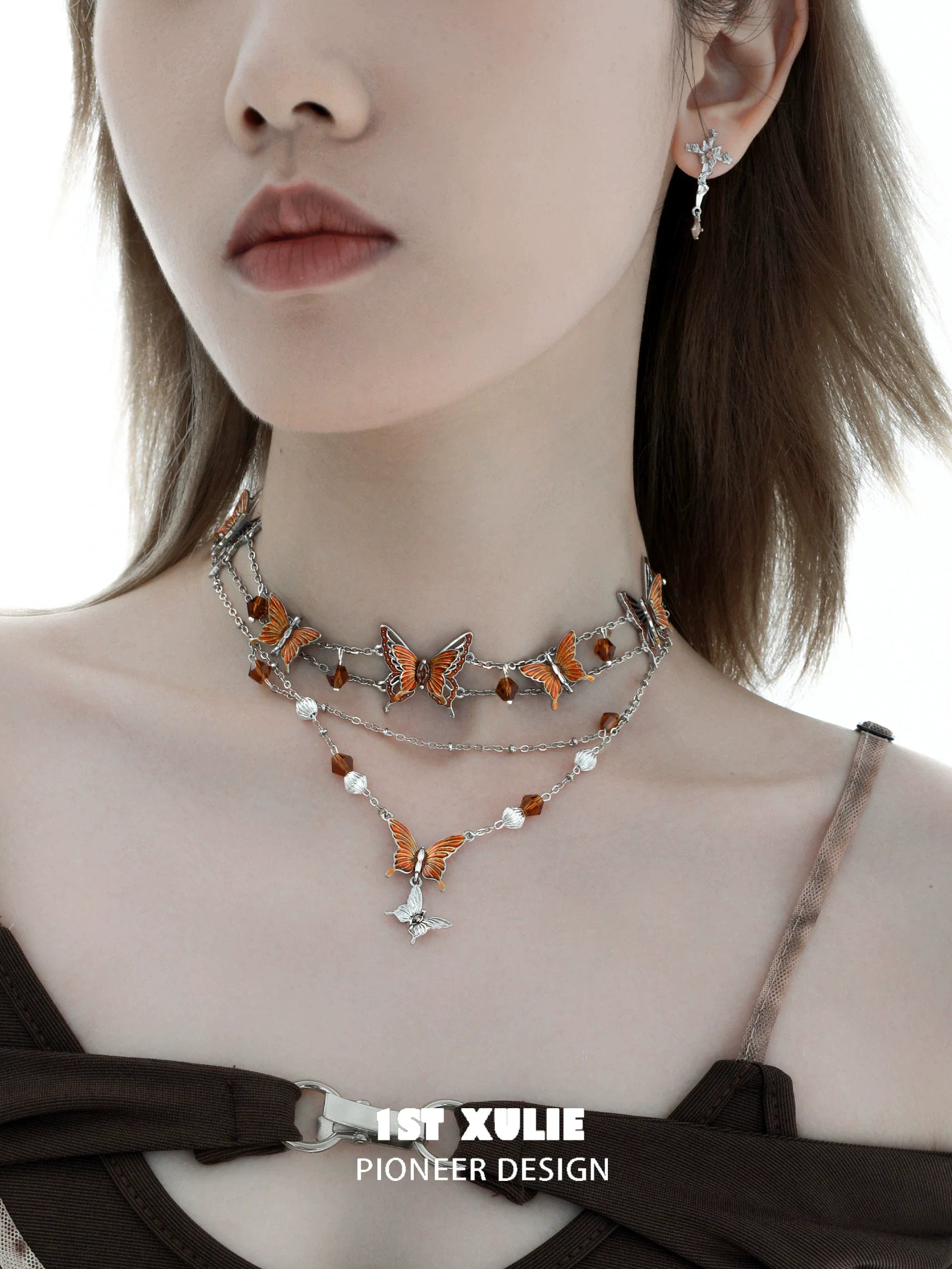 Gothic butterfly necklace featuring intricate orange butterflies and silver accents, styled elegantly on a model