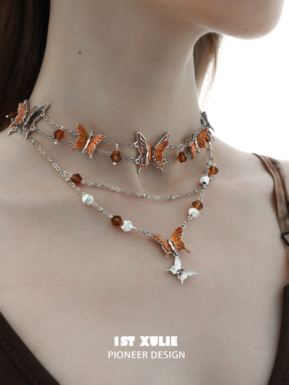 Gothic butterfly necklace featuring silver chains and orange butterfly charms for a unique accessory