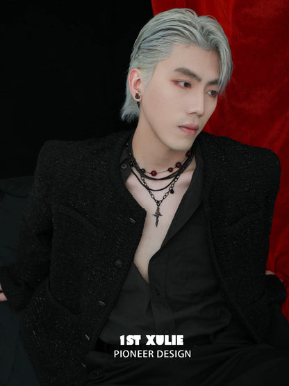Stylish man showcasing a gothic cross necklace layered with beads for a trendy look