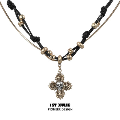 Gothic cross necklace by 1STXULIE featuring a unique skull pendant and intricate bead details