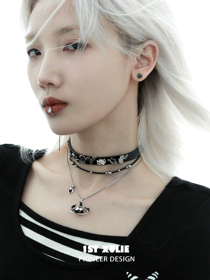 Gothic night owl cat necklace layered with black choker worn by model with silver hair