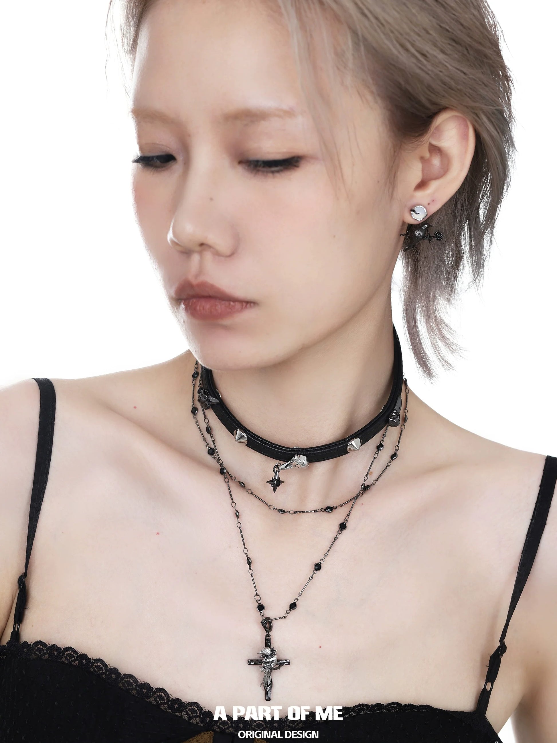 Gothic raven cross necklace layered with silver charms for a bold and edgy look