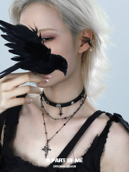 Gothic raven cross necklace layered with a choker and worn by a model with a black bird.