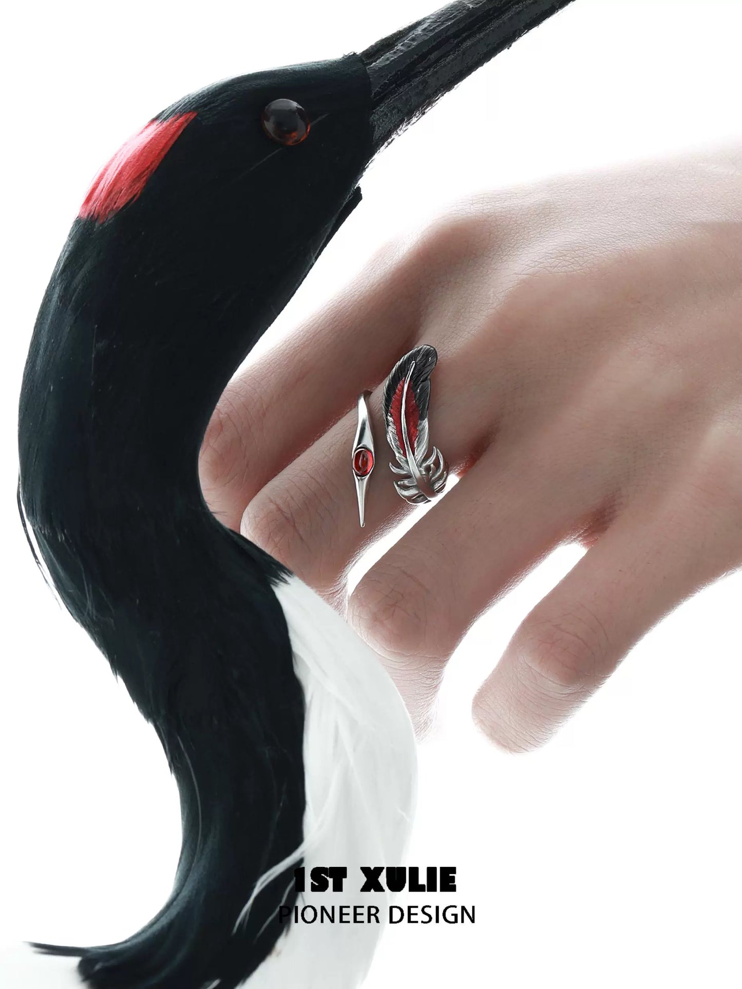Gothic silver crane ring displaying intricate design on a model's hand beside a crane illustration