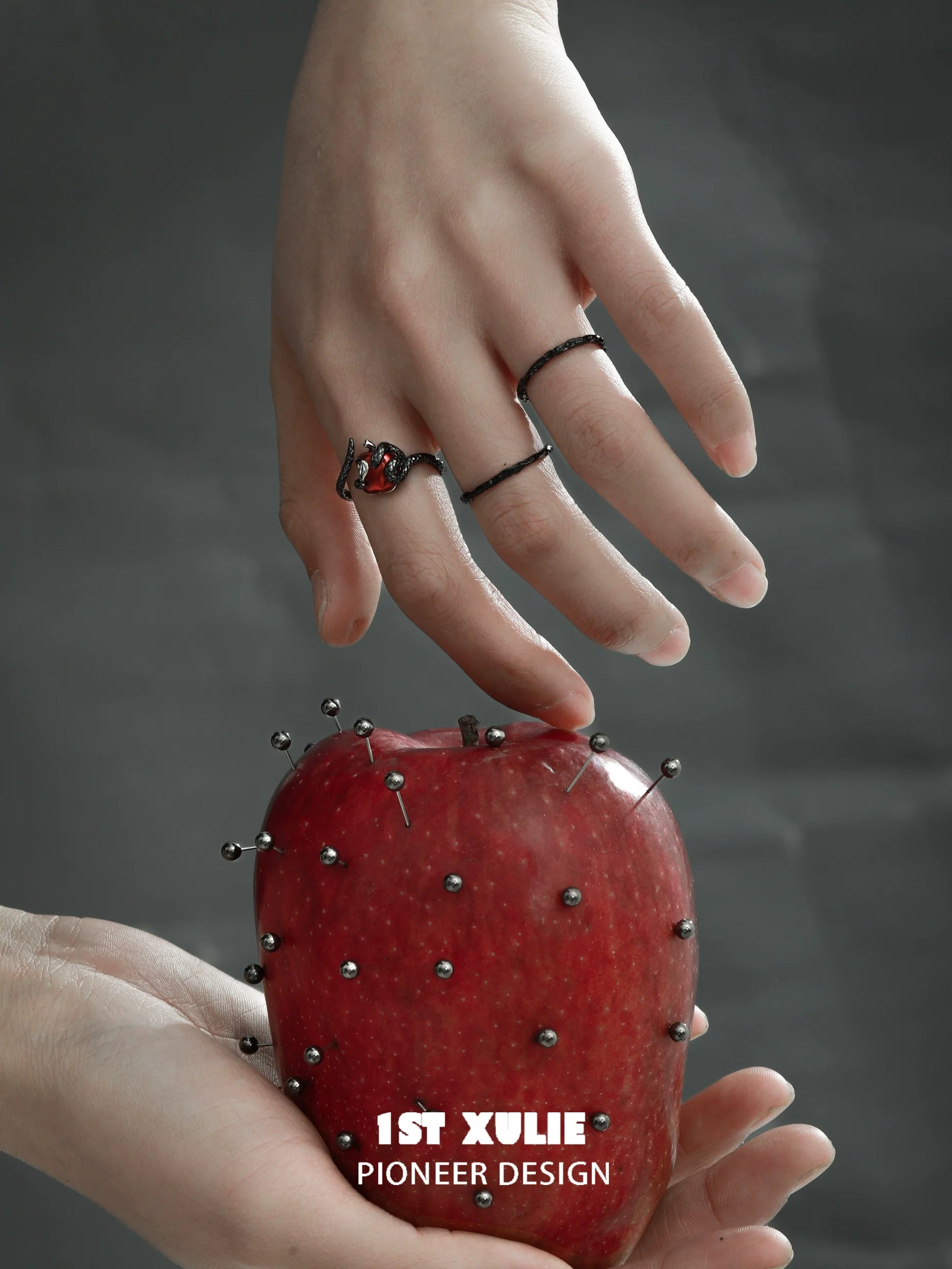 Gothic snake apple ring displayed on a hand holding a spiked red apple for unique fashion style