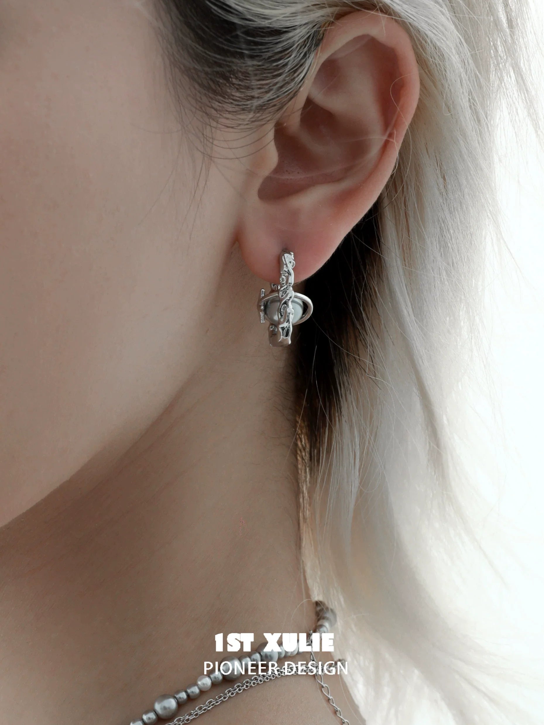 Stylish gray pearl star earrings hanging elegantly on a model's ear