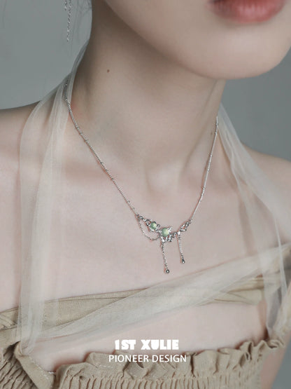 Elegant green gem silver necklace displayed on a model, enhancing a chic outfit