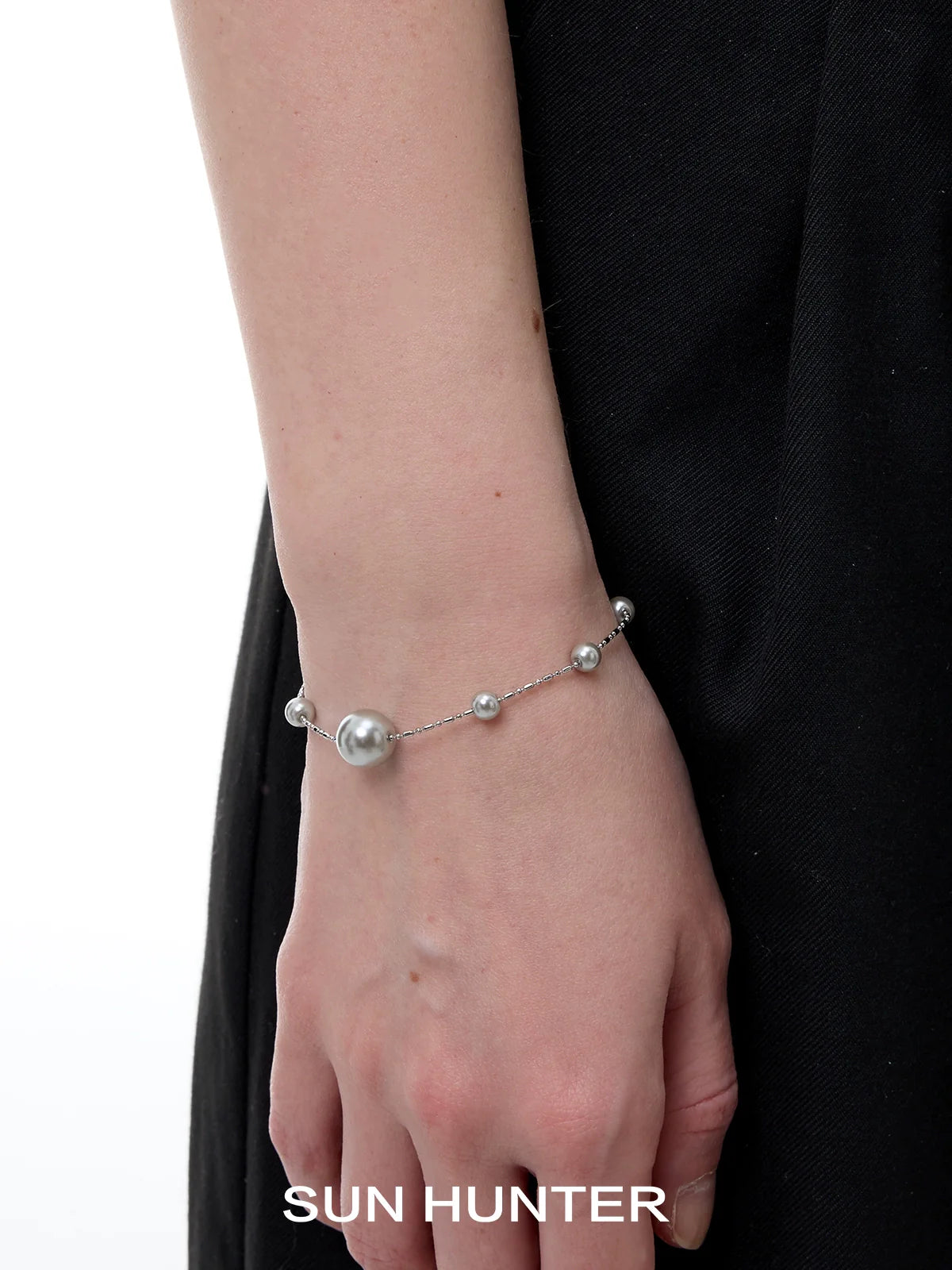 Stylish SUN HUNTER gypsy star pearl bracelet with elegant silver accents on a wrist