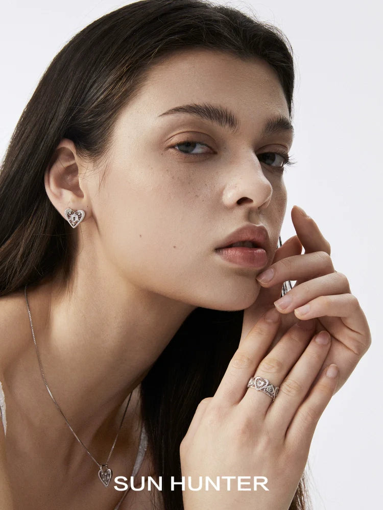 SUN HUNTER Heart Lock Ring showcased on a model's hand with matching heart earrings in a stylish setting
