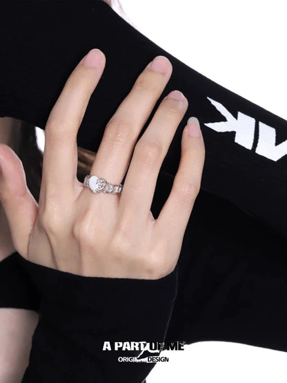 A PART OF ME heart vow ring showcased on a woman's hand with a stylish black outfit