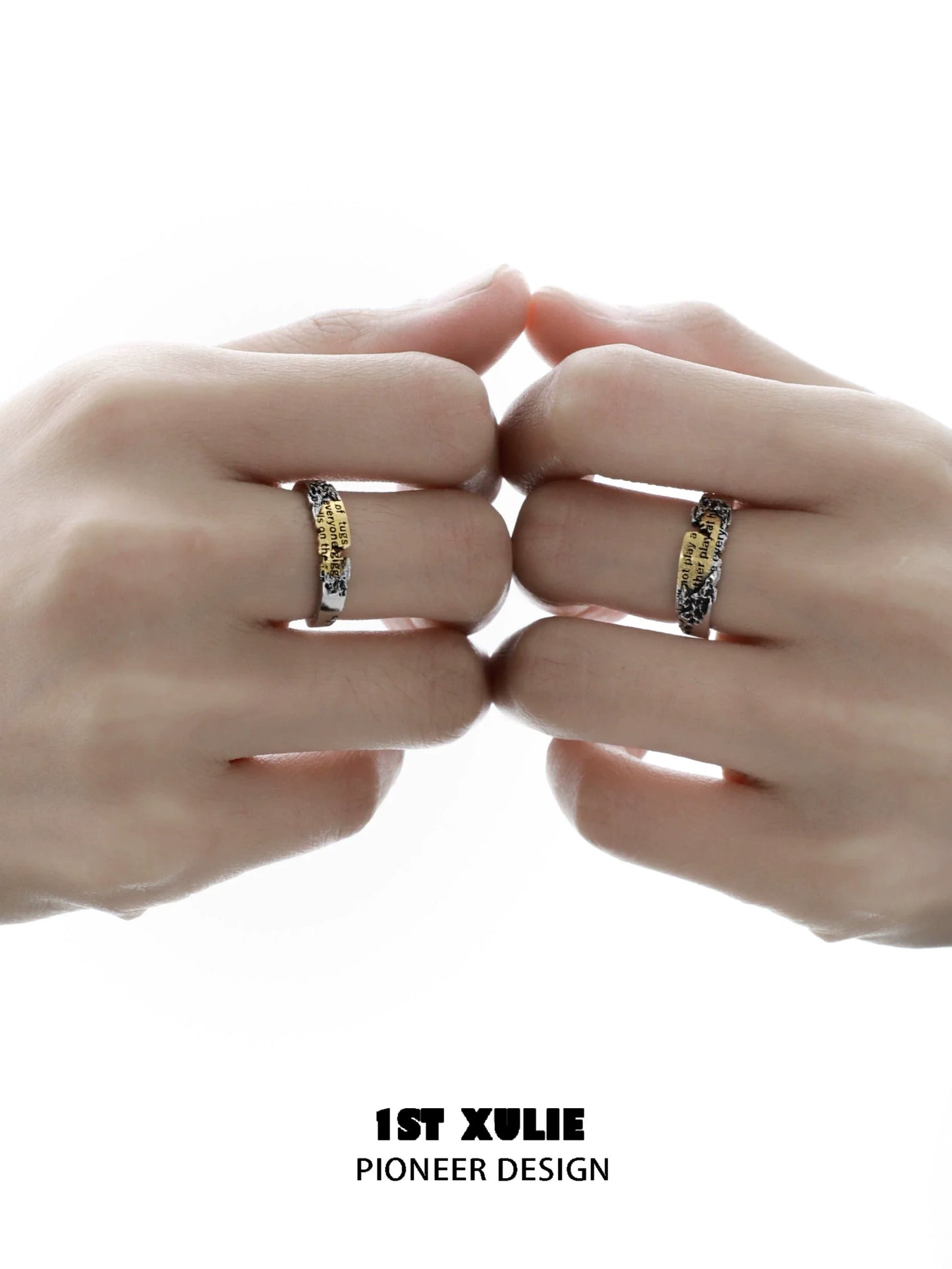 Two hands wearing the Immortal Love Letter silver ring featuring unique engraving design
