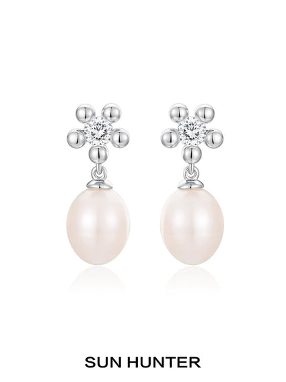 Elegant SUN HUNTER island flower pearl earrings with sparkling flower design and creamy pearl drop