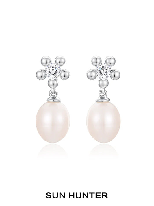 Elegant SUN HUNTER island flower pearl earrings with sparkling flower design and creamy pearl drop