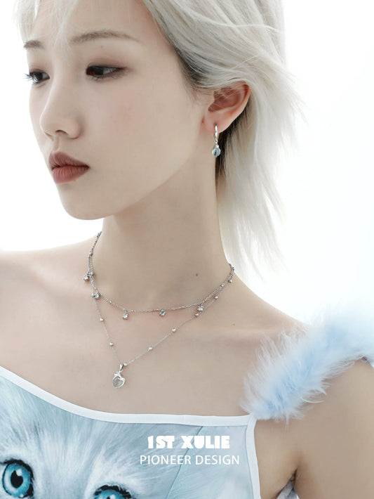 Elegant model wearing a kitten necklace for summer featuring delicate charms and a layered design