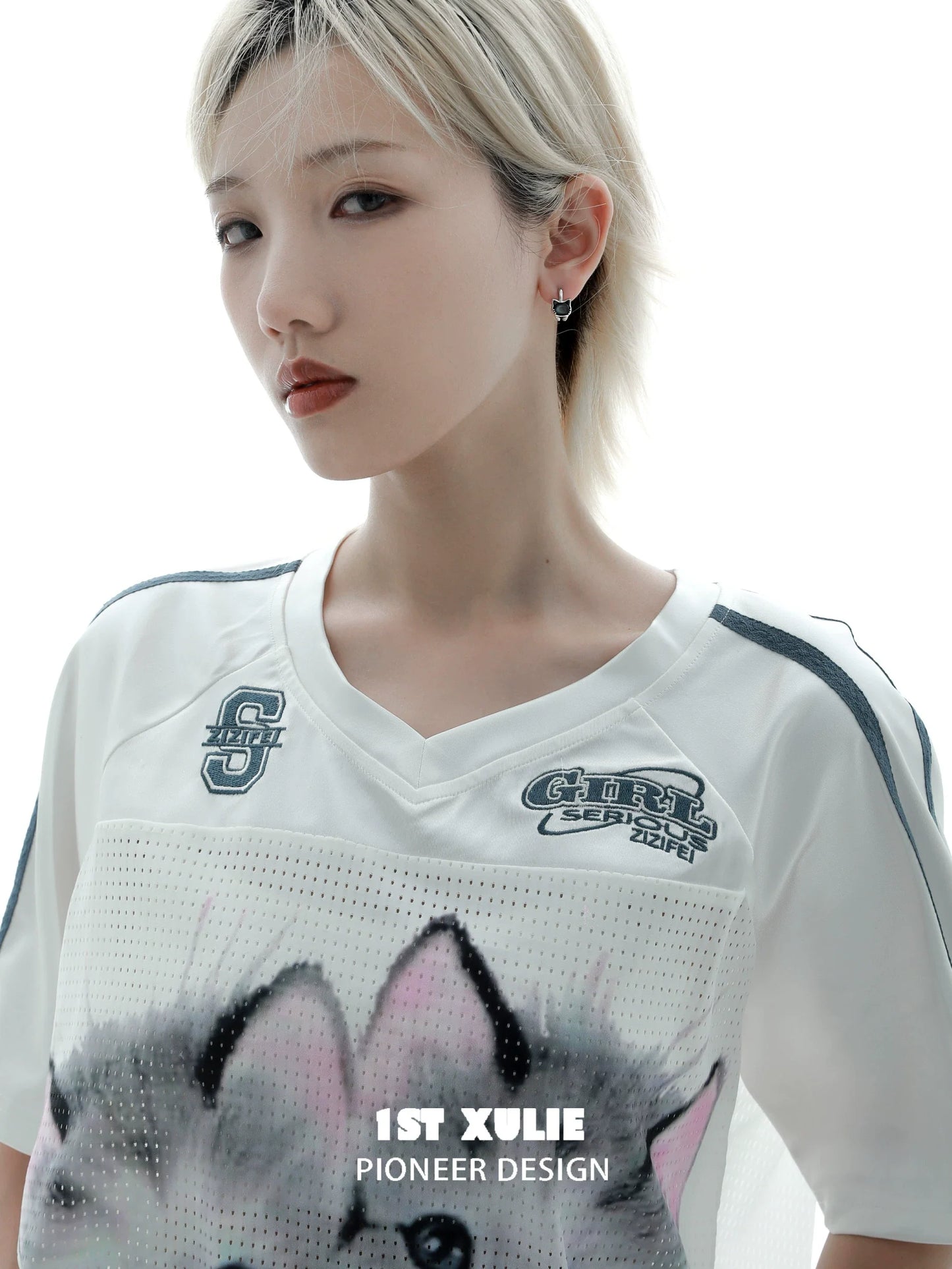 Fashionable model wearing kitten stud earrings alongside a sporty 1ST XULIE shirt