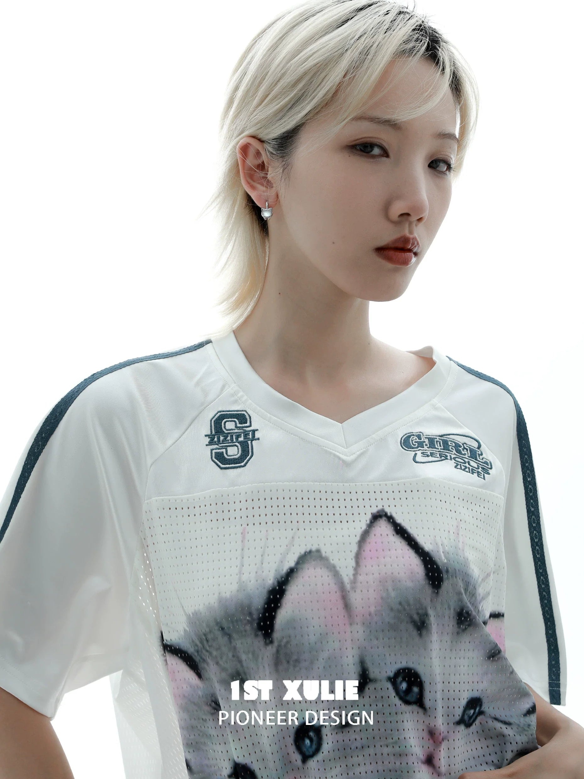 Model wearing 1STXULIE kitten stud earrings with a graphic cat shirt for a trendy look