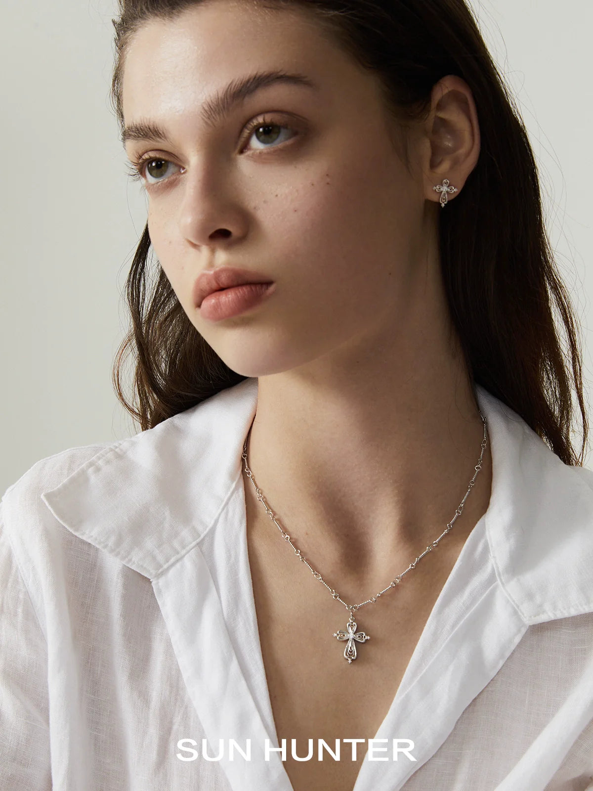 Elegant SUN HUNTER lace cross necklace featuring a delicate design with matching earrings for a refined look