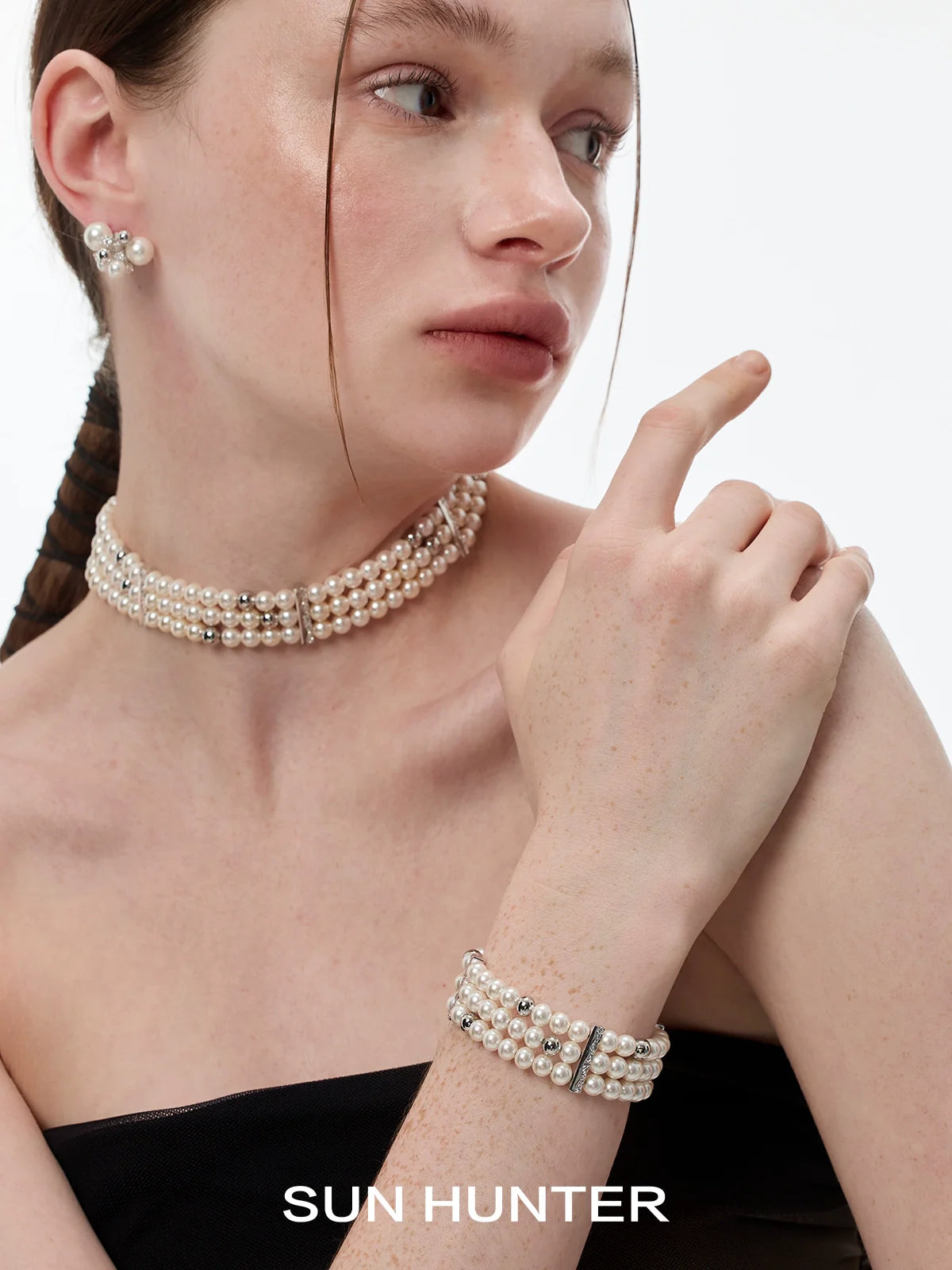 Elegant layered pearl bracelet by SUN HUNTER paired with matching pearl jewelry for a chic look