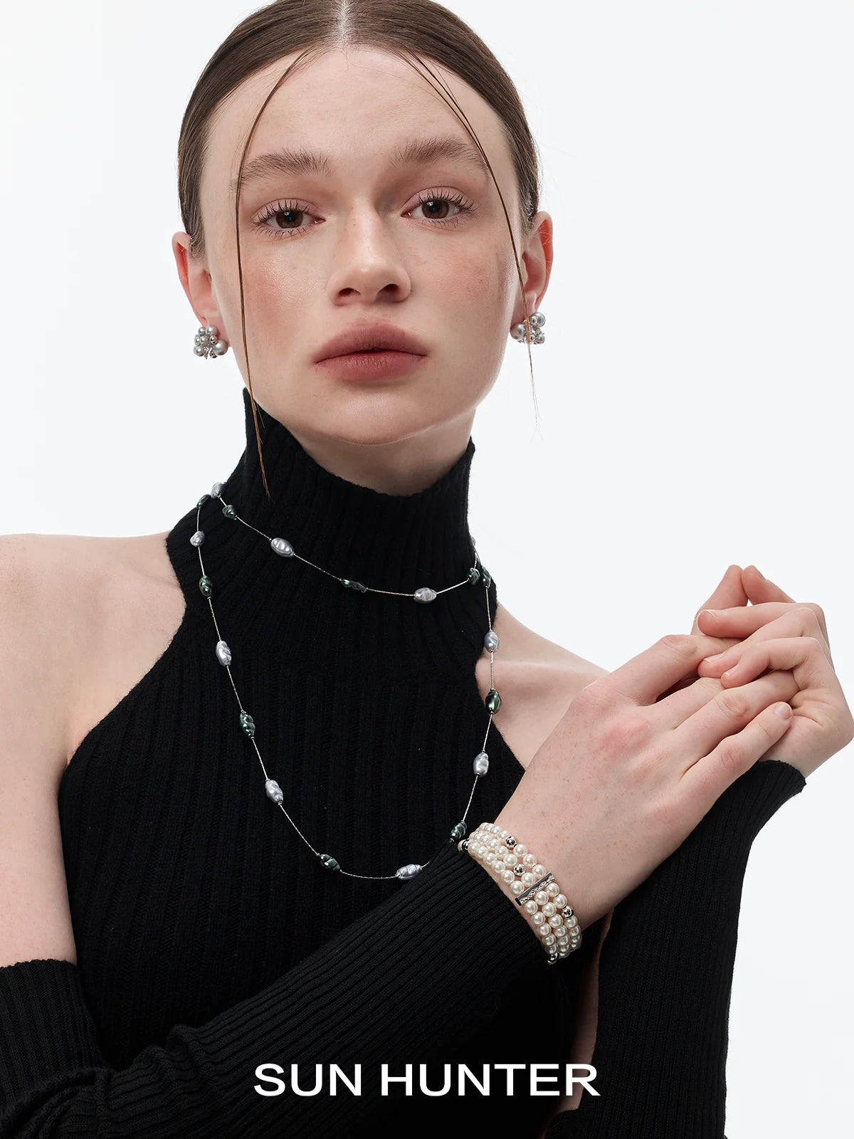 Elegant layered pearl bracelet paired with a layered pearl necklace, showcased on a model wearing a black turtleneck