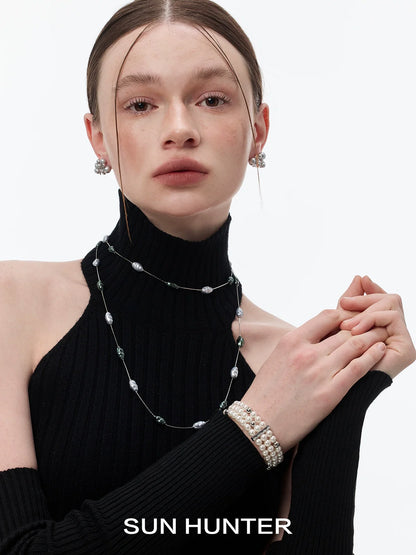 Elegant layered pearl bracelet paired with a layered pearl necklace, showcased on a model wearing a black turtleneck